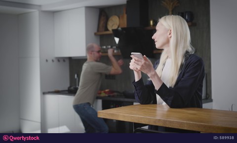 Happy cheerful couple husband and wife in the kitchen, man cooks breakfast, makes woman laugh video 589938